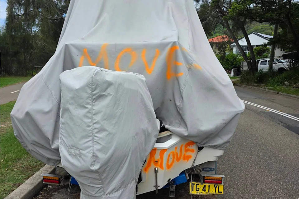 A boat parked on Sydney street with 'move' spray painted on it. 