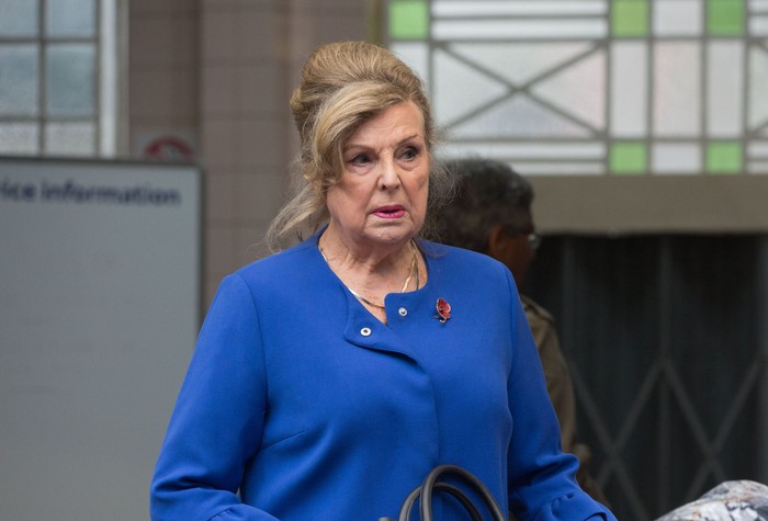 Ann Mitchell in a blue coat as Cora Cross in a 2018 episode for EastEnders.