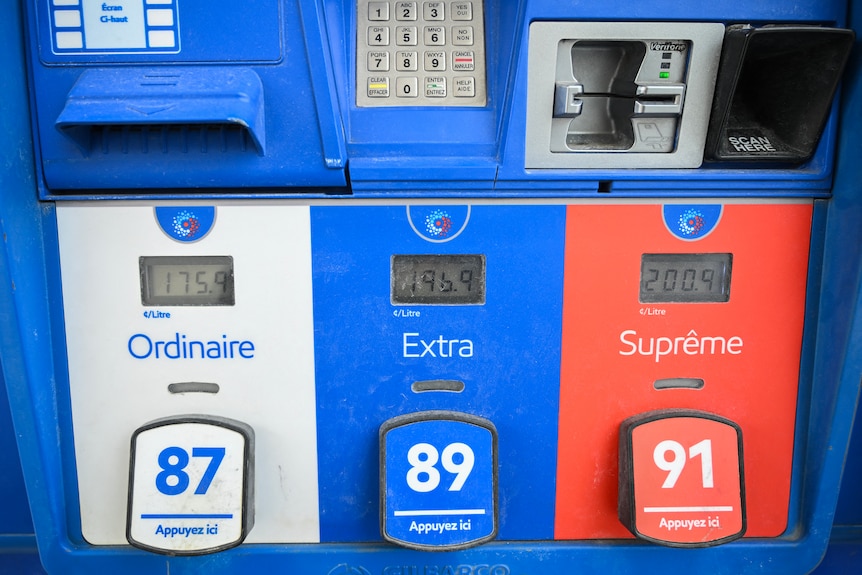White, blue and red petrol pumps displaying various prices with French Canadian labels.