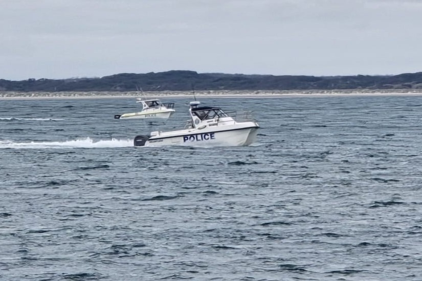 Police boats cruising on a waterway.