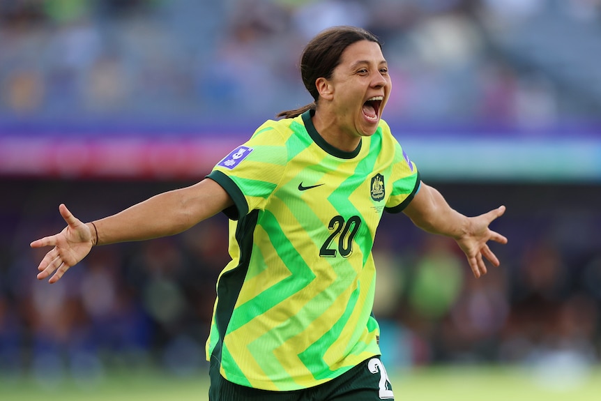 Matildas captain Sam Kerr has arms outstretched as she celebrates a goal.