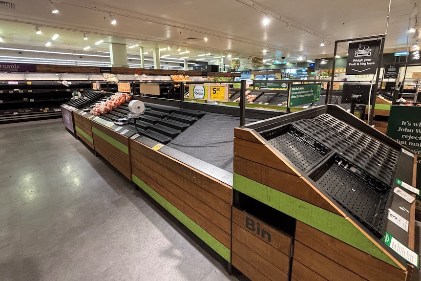 Empty supermarket shelves where fruit and vegetables are usually displayed.