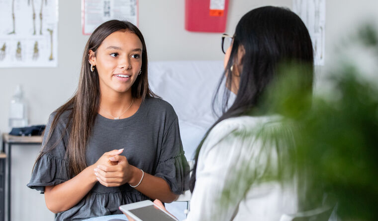 Teenage girl talking to doctor