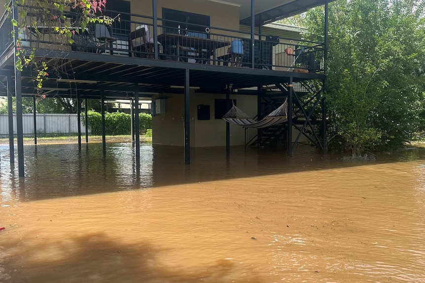 Brown floodwaters rise up from the ground floor of a home.
