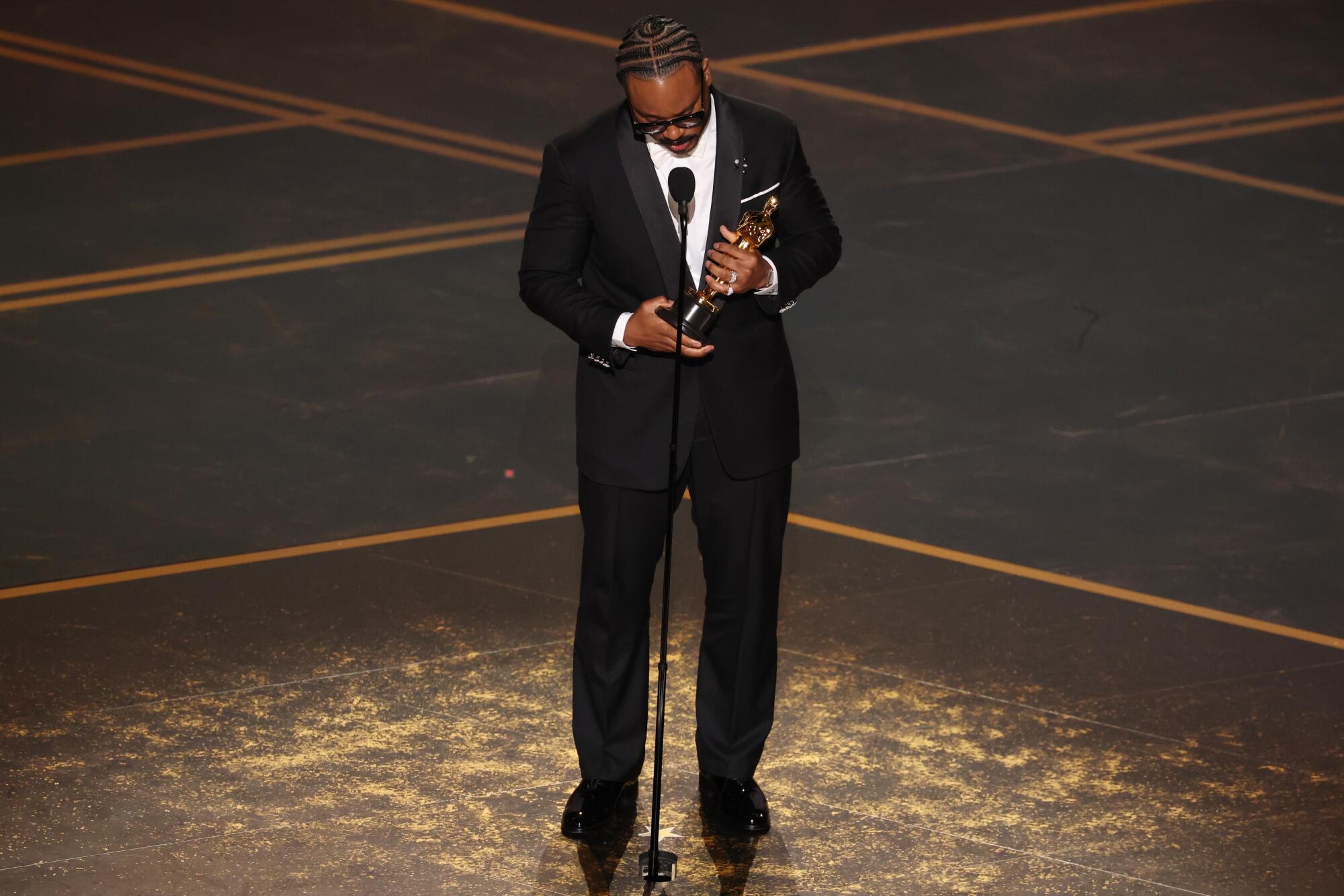 Writer-director Ryan Coogler holds the Oscar for original screenplay for "Sinners" during the 98th Academy Awards.