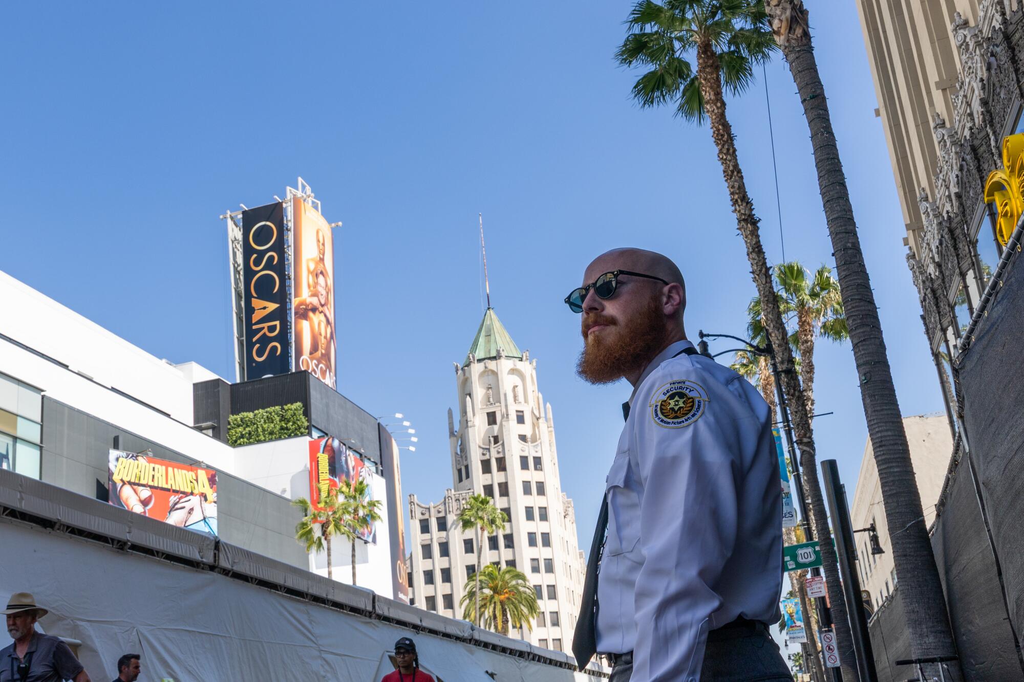  A security officer keeps an eye on the red carpet tent at the Oscars