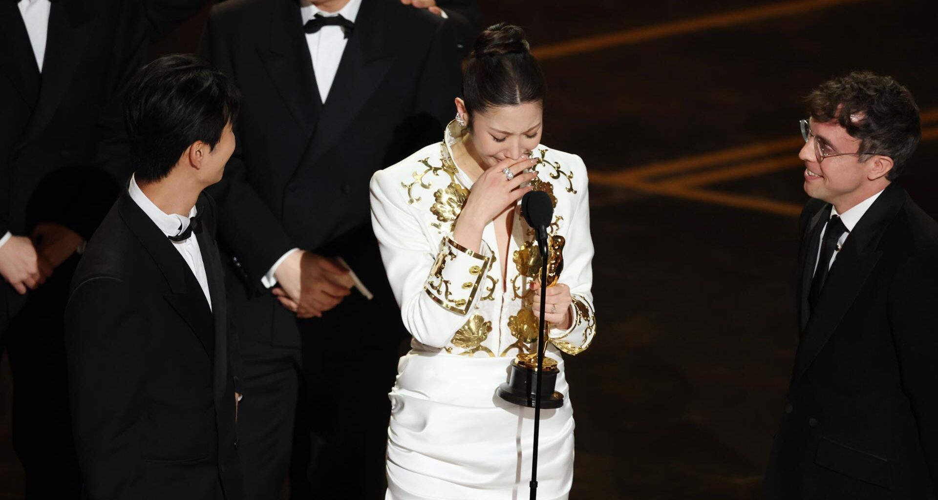 From left, Lee Yu-han,  EJAE, and Mark Sonnenblick react after winning the Oscar for Best Music (Original Song) for