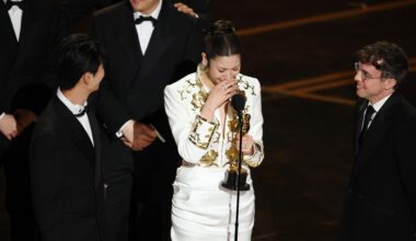 From left, Lee Yu-han,  EJAE, and Mark Sonnenblick react after winning the Oscar for Best Music (Original Song) for
