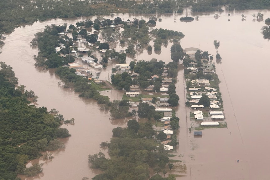 Brown water spills across streets in a small community, shown from above.