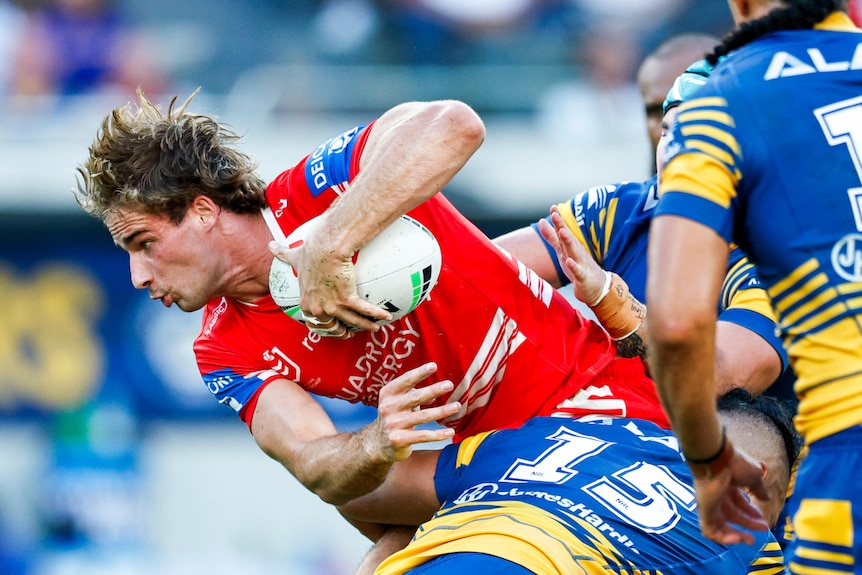 Ryan Couchman of the Dragons is tackled while running with the ball in an NRL match