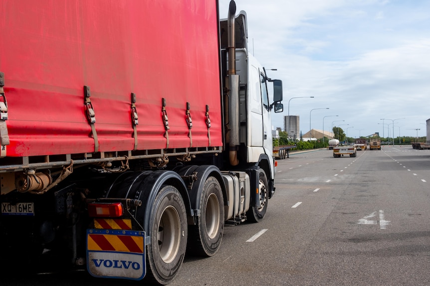 A truck lines up in a parking bay outside a busy coastal port