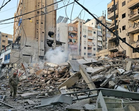 A man walks past debris at the site of an overnight Israeli airstrike in Beirut’s southern suburb of Bir al Abed on Tuesday