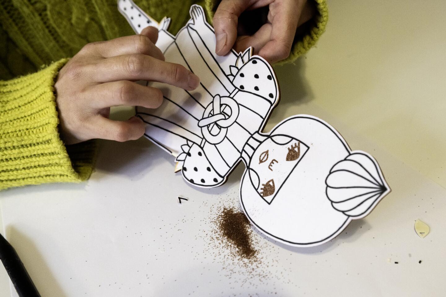 Japanese artist and illustrator Naoshi removes sand from a sunae project