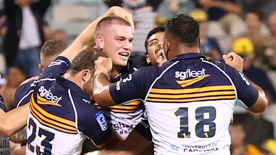 Brumbies players celebrate a winning try by Charlie Cale against the Blues.