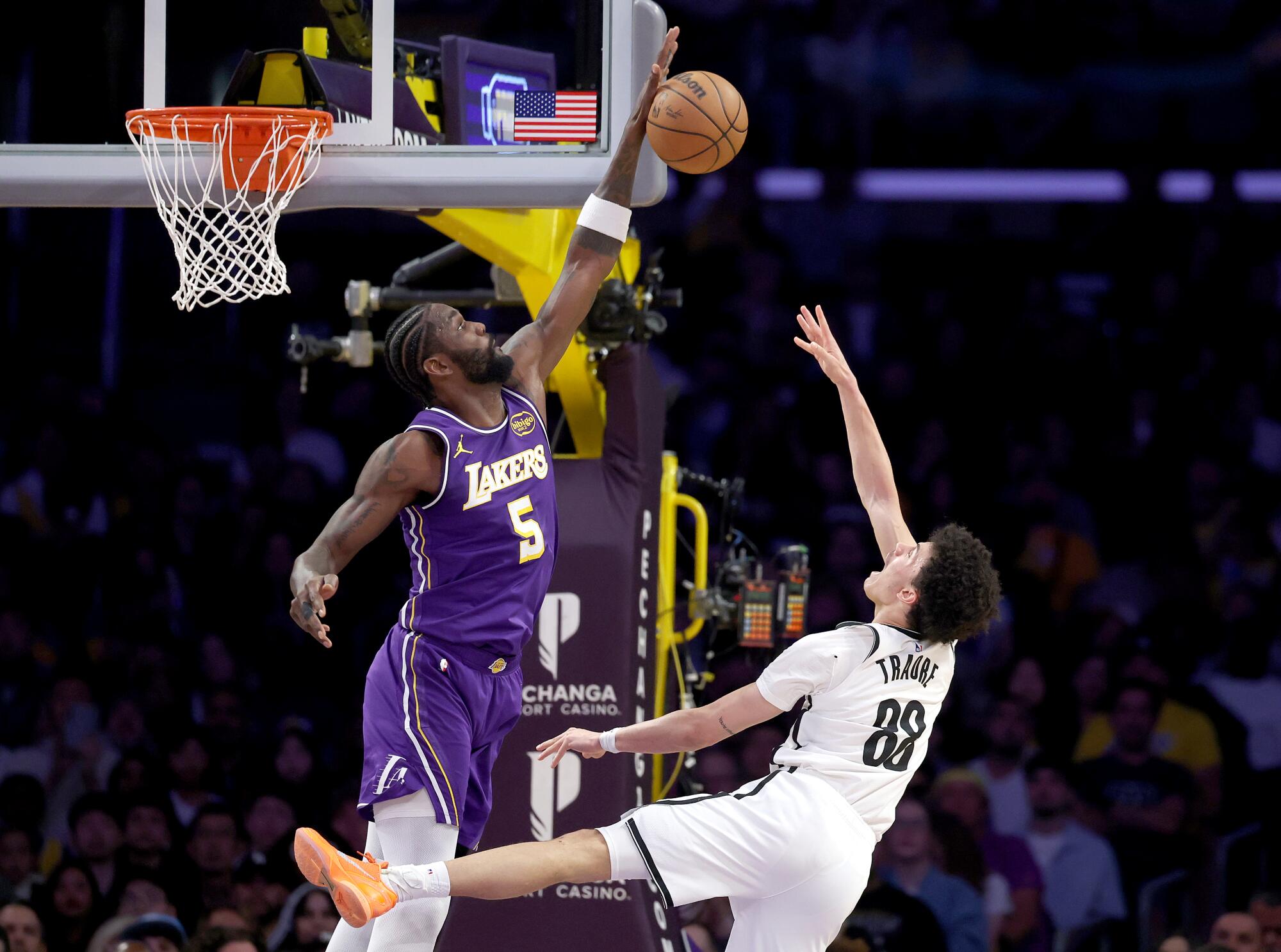 Lakers center Deandre Ayton, left, blocks a shot by Brooklyn Nets guard Nolan Traore.