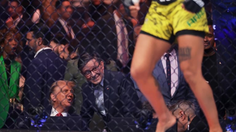 President-elect Donald Trump talks to House Speaker Mike Johnson, R-La.,...