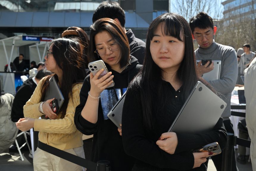 People queue to have OpenClaw installed on their laptops at Baidu headquarters in Beijing on March 11, 2026.