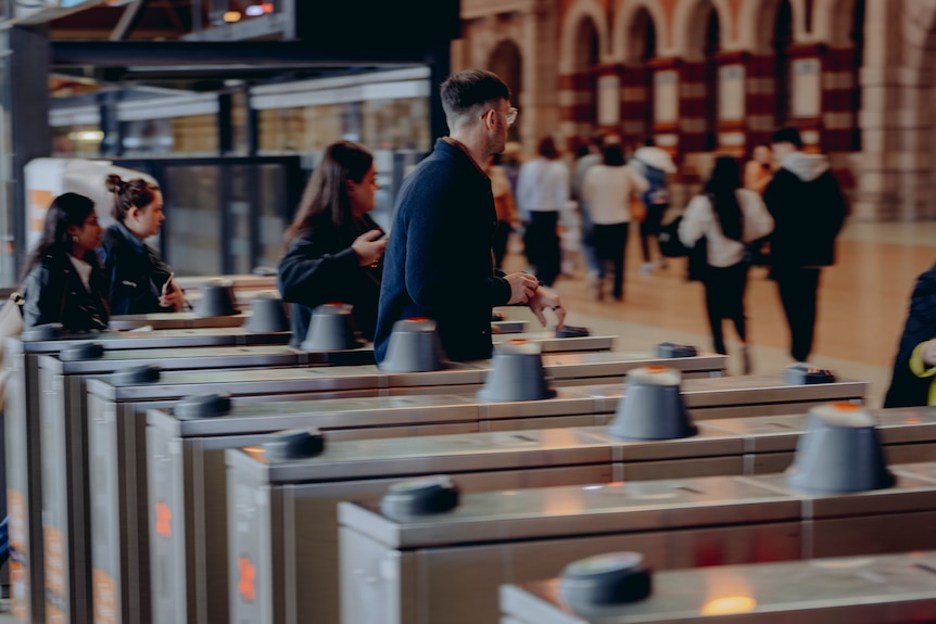 train commuters walk through the opal ticket machines at sydney's opal railway station