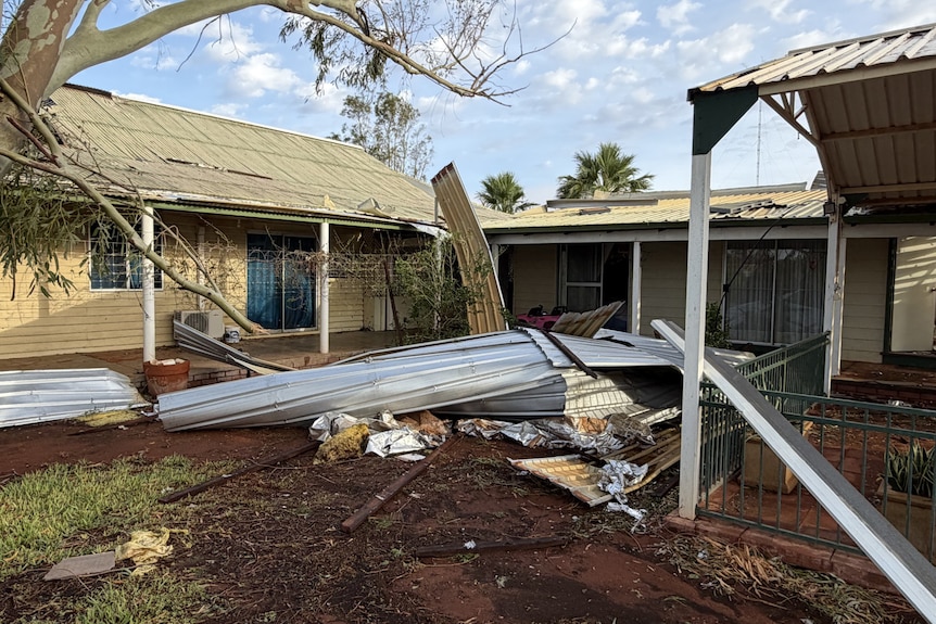 Roof sheeting on the ground outside a damaged homestead on an outback station.
