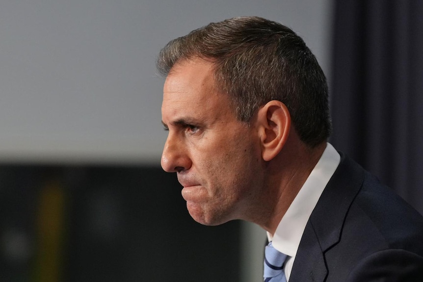 A man in a suit from a side profile with his chin jutted out defiantly.