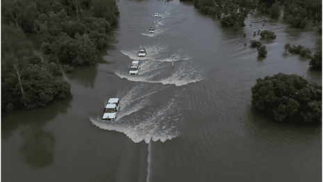 NT floods: emergency service convoy travels along flooded Victoria Highway near Katherine – video