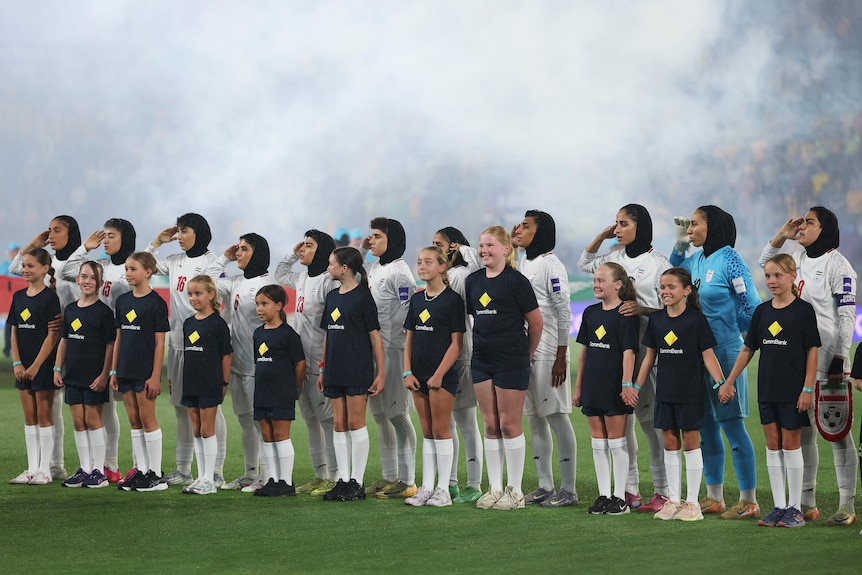 The Iranian women's team salutes the national anthem before an Asian Cup game against Australia.