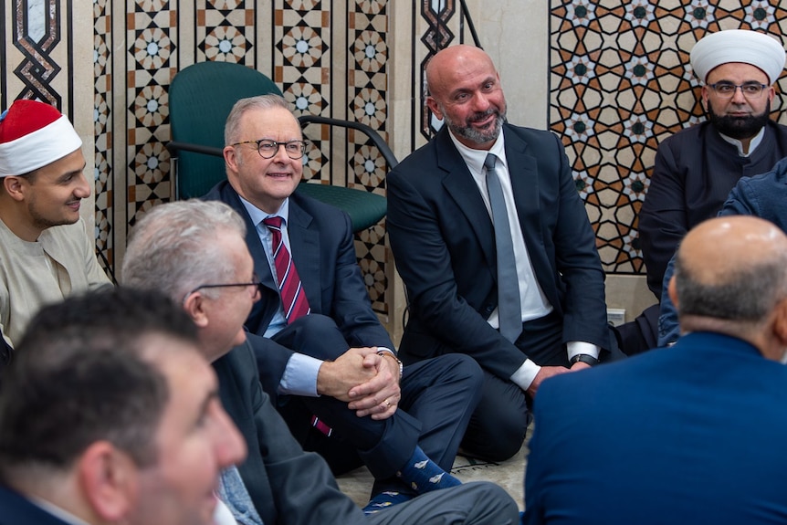 Prime Minister Anthony Albanese sits with people at a mosque.