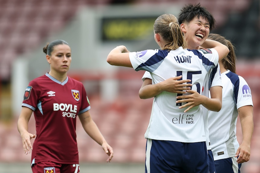 Toko Koga of Tottenham Hotspur celebrates with Clare Hunt share a hug on the field.