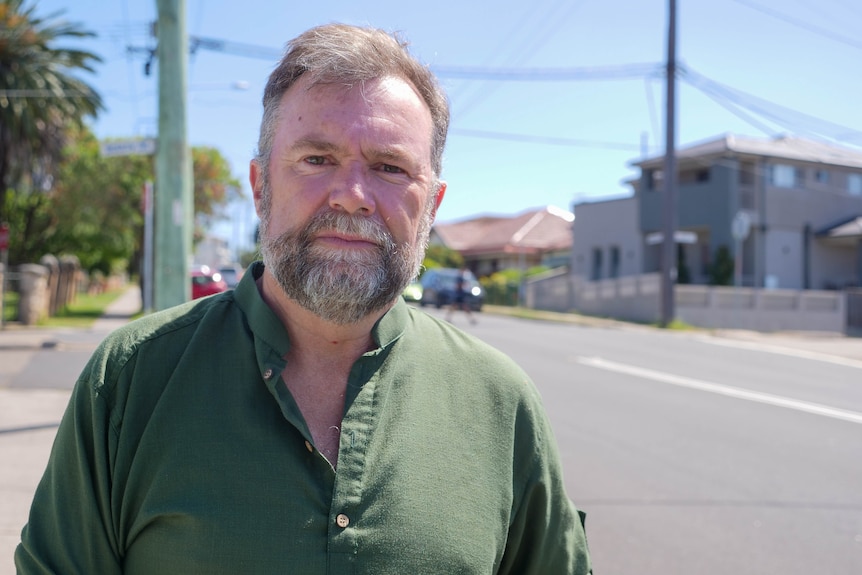a man looking straight ahead on a suburban street