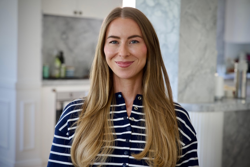 Woman with long hair smiles at the camera.