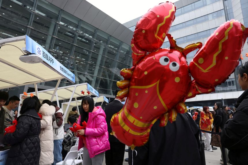 Participants line up near a lobster-shaped balloon to set up and install OpenClaw outside the Baidu offices in Beijing.