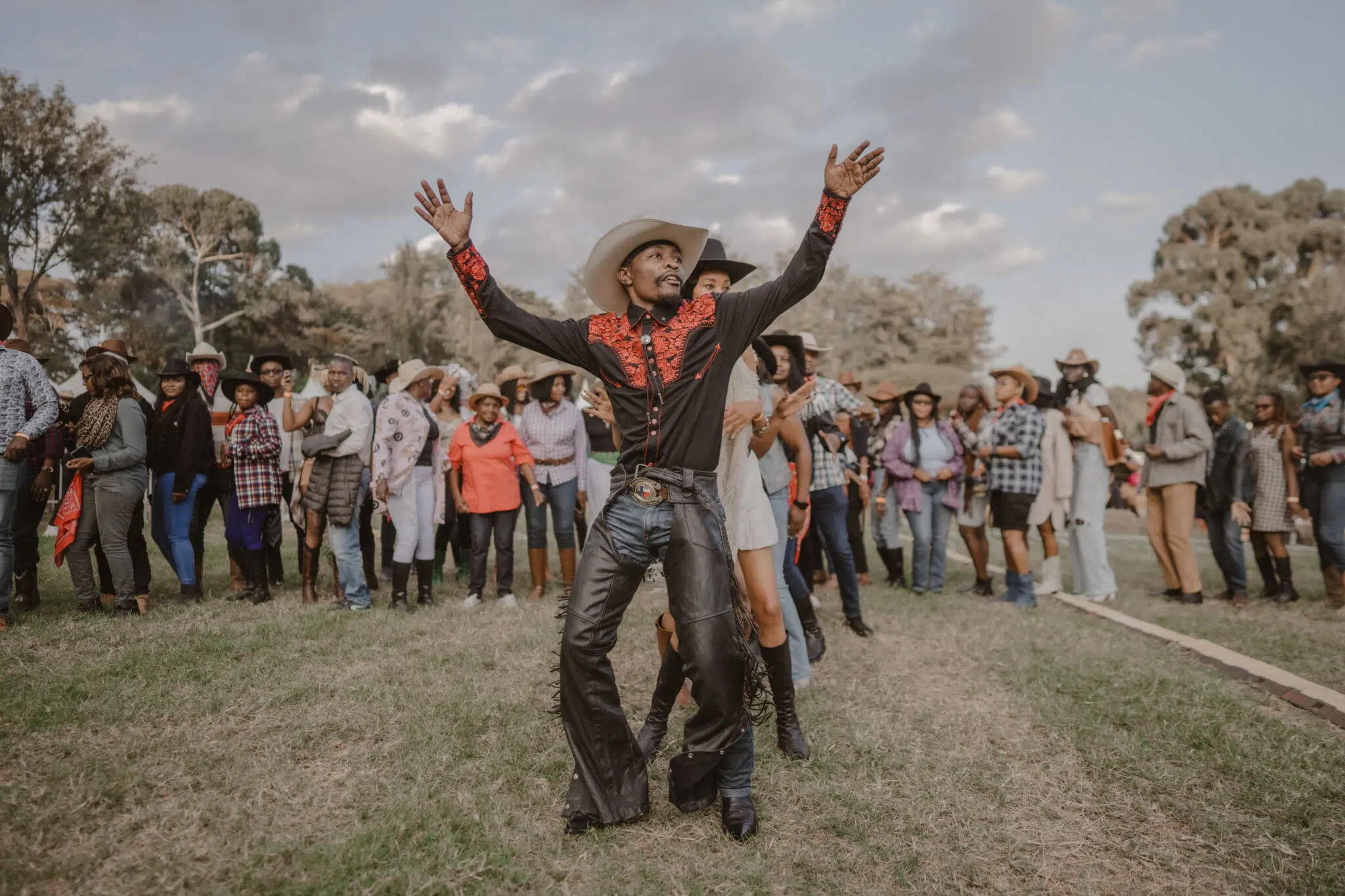 Sheriff Knight (c.) leads the line dance during International Cowboy Day.