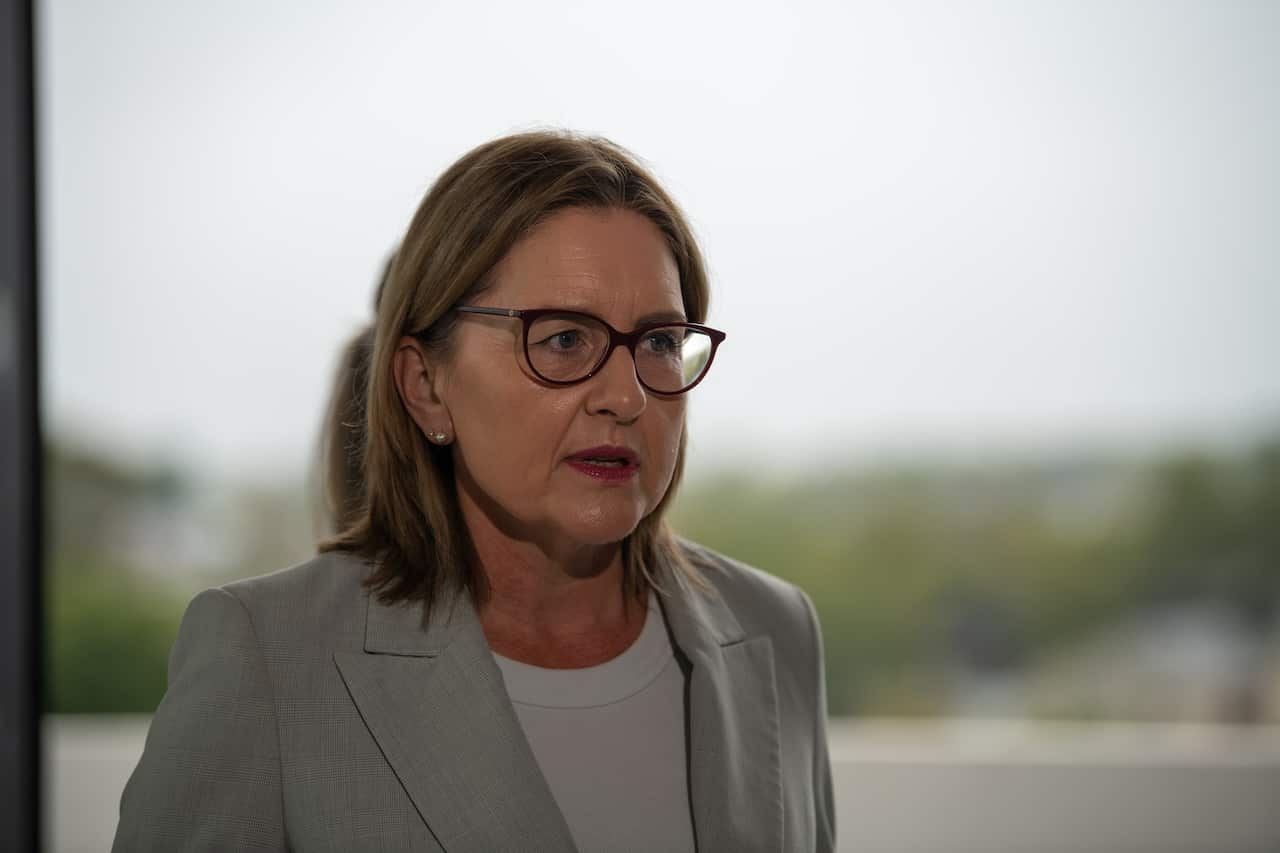 A woman wearing a suit and glasses.