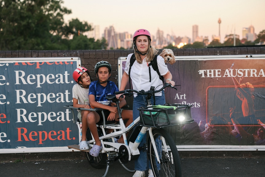 a woman and her children and dog on a bike