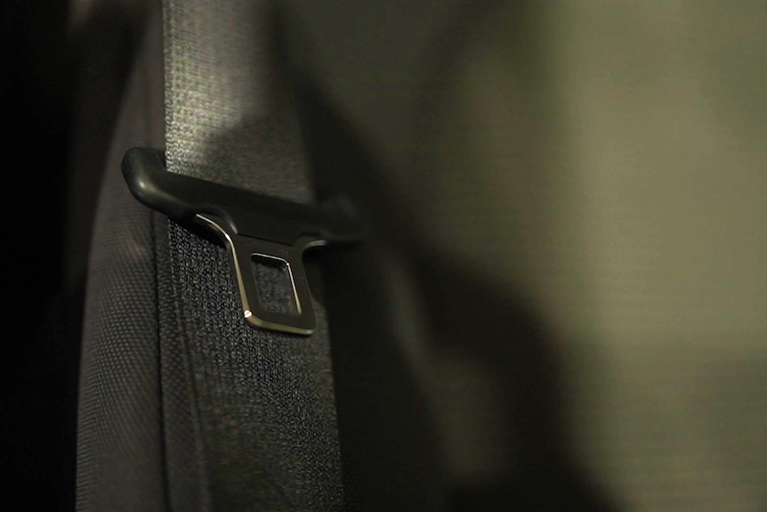 A seatbelt rests on a car seat