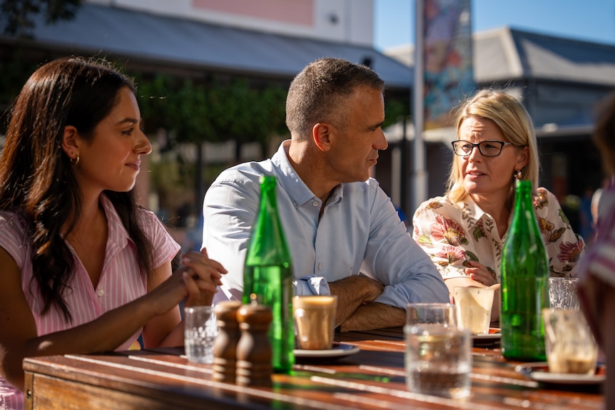 Premier Peter Malinauskas sits at a table with Aria Bolkus and Alice Rolls