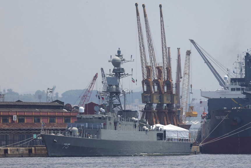 A naval vessel docked in a port. 