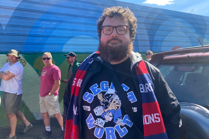 Football fans look at the camera.