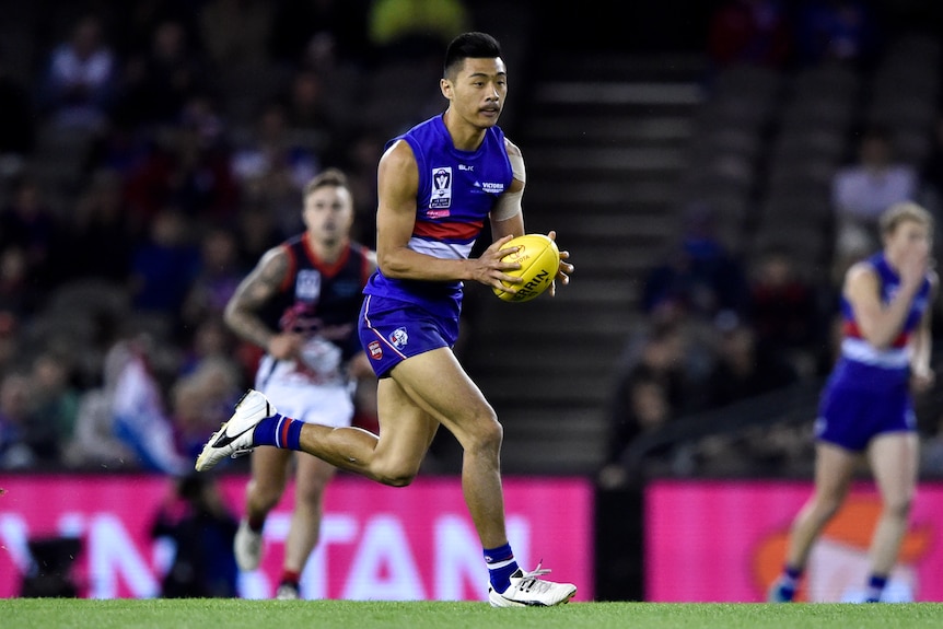 Man in football gear runs with ball