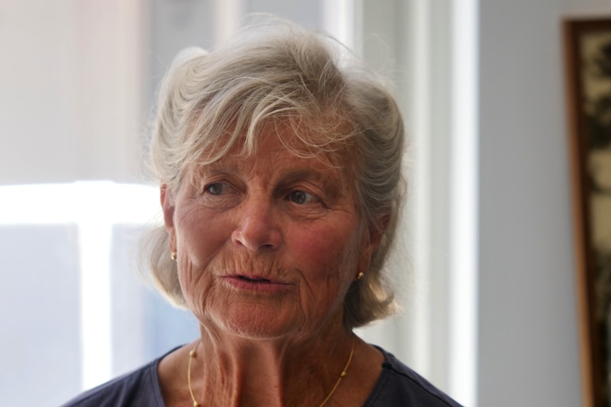 close up photo of older woman with short grey hair and serious expression