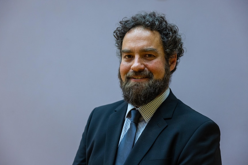A headshot of a shire president wearing a suit and tie