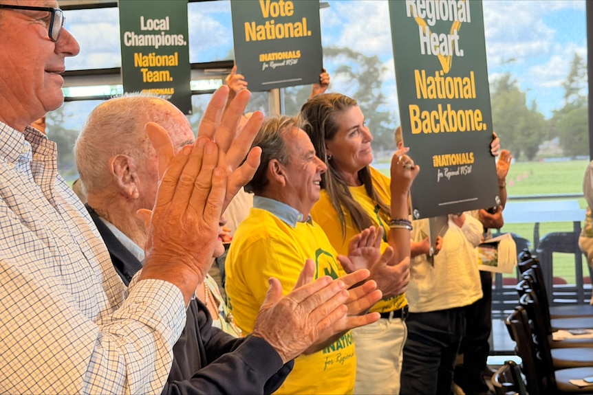 people dressed in nationals t shirts clapping