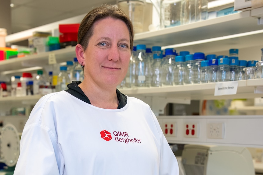 A woman in a white medical coat in a laboratory setting