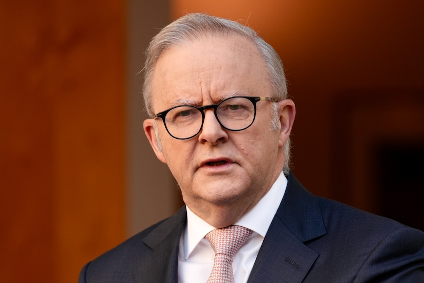 Anthony Albanese wearing glasses and looking stern.