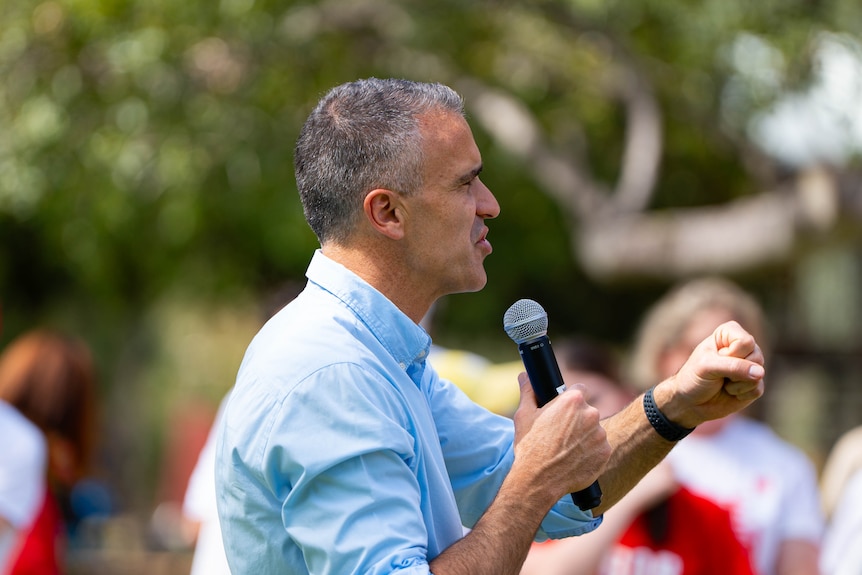 South Australian Premier Peter Malinauskas holding a microphone.
