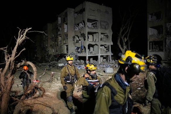 Israeli security forces and rescue teams work at the site struck by an Iranian missile in Arad.