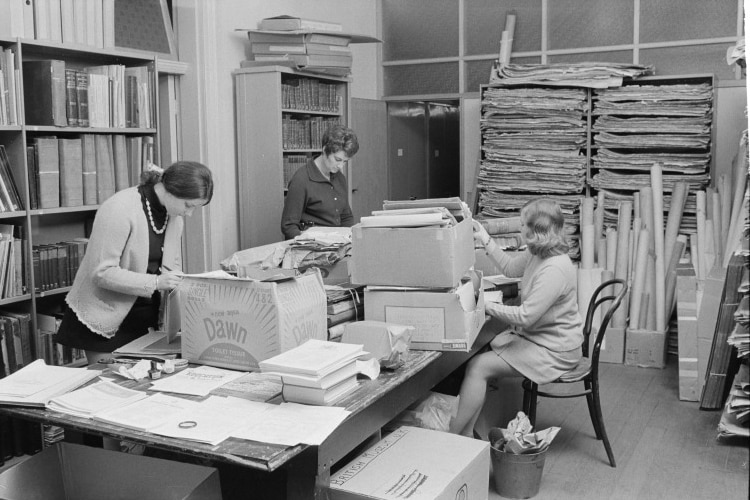 black and white photo of three women in the workroom of the archives in 1969