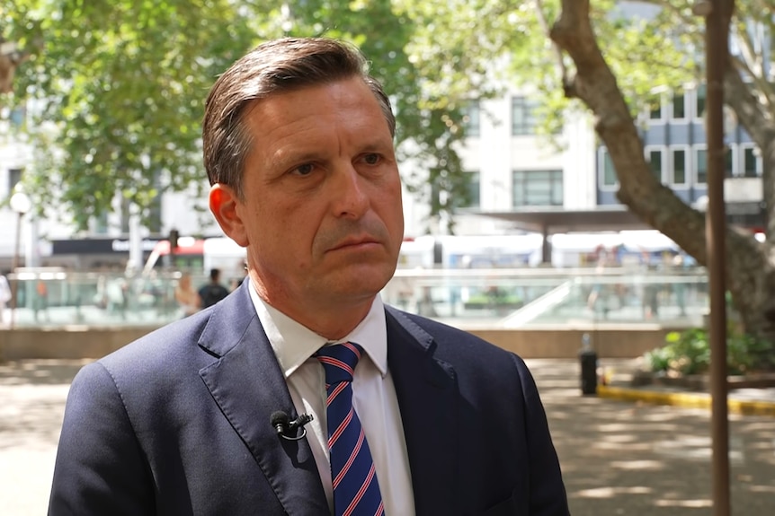 Commissioner Dametto looking serious while talking to a reporter in the shade near Town Hall in Sydney.