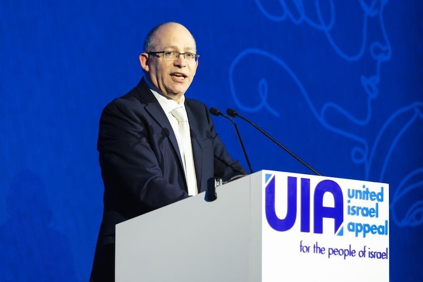 A man speaks at a lecturn.