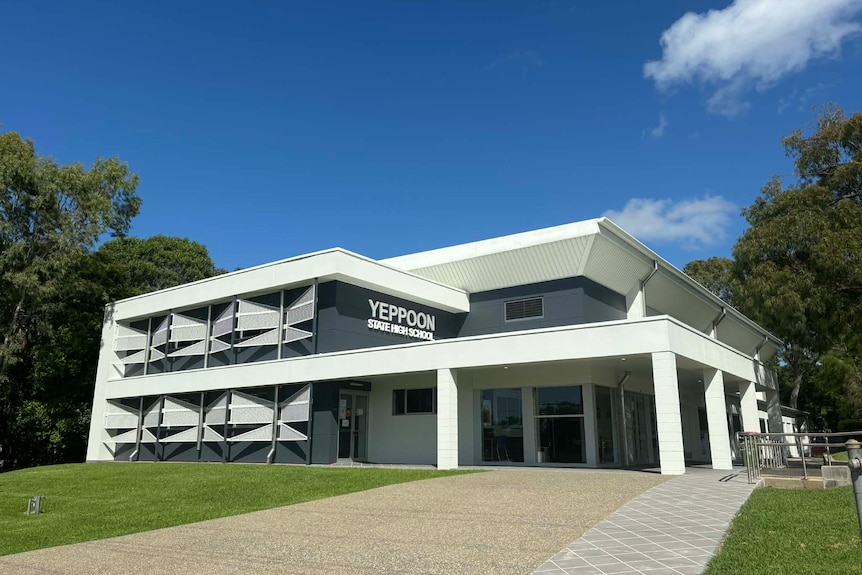 A light-coloured, two-storey building with "Yeppoon State High School" lettered on it.